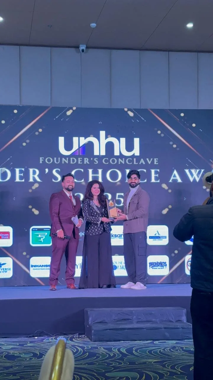 Charu Wadhwa receiving the Founder's Choice Award on stage at the UNHU Founder's Conclave